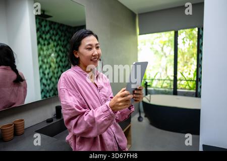 Happy young woman working remotely from home, enjoying a relaxed and comfortable atmosphere Stock Photo