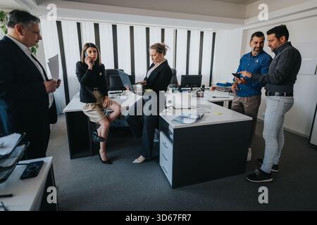 Professional team collaborating in a modern office space during a busy workday Stock Photo