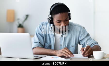 Serious african american student in headphones studying foreign language online Stock Photo