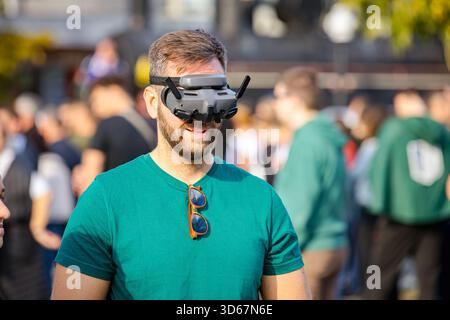 Young man, using fpv goggles and remote controller to operate generic design, fly and control drone. Professional operator, pilot wearing virtual real Stock Photo