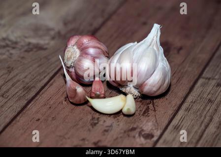 Garlic bulb and clove isolated. Garlic bulbs with cloves on wooden background Stock Photo