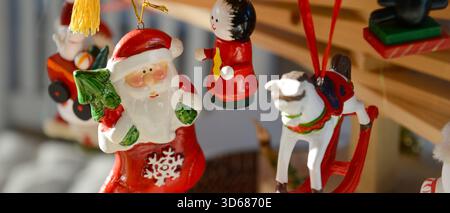 Christmas decorations featuring Father Christmas and other wooden figurines, hung from a homemade fir tree branch made from wooden planks, banner form Stock Photo