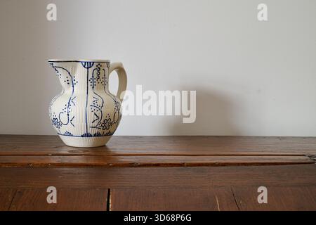 old Delft  milk jug on a piece of furniture from front Stock Photo