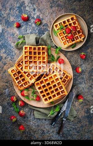fresh baked homemade Brussels waffles with fresh strawberries on a plate Stock Photo