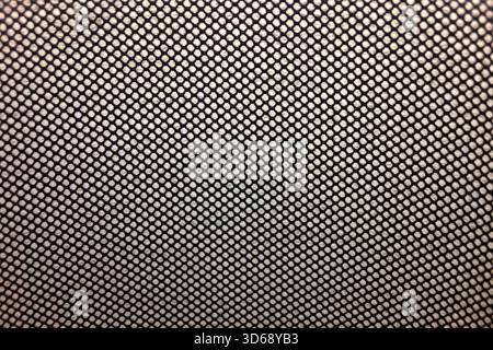 close-up view of a tightly woven mesh fabric featuring a repeating, uniform diamond pattern and texture with small holes, polyester textile suitable f Stock Photo