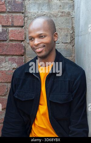 portrait of a young african man outdoors, shaved head and casual clothes, single, Stock Photo