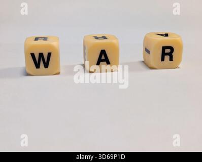 Three letter dice spelling out the word 'WAR' on a plain white background Stock Photo