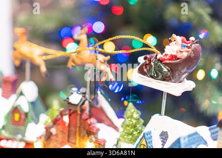 Centrally located Christmas tree, decorated with multi-colored lights and assorted ornaments, including large chocolate Santa Claus and reindeer figur Stock Photo