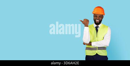 Nice Offer. Smiling Black Civil Engineer Pointing Aside At Copy Space Stock Photo