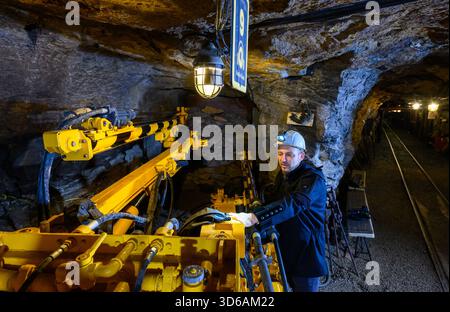 PRODUCTION - 14 November 2025, Saxony, Annaberg-Buchholz: Gunnar Lenhard stands at a drill rig underground in the Markus Röhling Stolln mine in Annaberg-Buchholz. In today's visitor mine, an old mining custom is kept alive, the Mettenschicht. The Mettenschichten has existed for around 400 years and is the miners' last shift before Christmas. When the visitor mine was established, the idea was born to revive this custom. Up to 80 people are entertained down here by candlelight on several dates during the Advent season, with bacon fat sandwiches and lentil soup, accompanied by music. The traditi Stock Photo