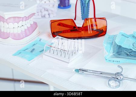 Various instruments, dental models, and hygiene items are laid out on the table in the dental office. natural light Stock Photo
