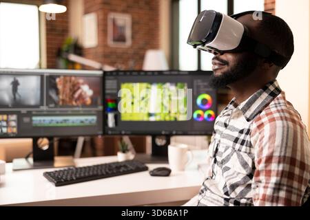 Black male video editor using augmented reality tools and VR headset, checking color and tone of footage during post production. Creative man immersed in 3d technology, reviewing cinematic edits. Stock Photo
