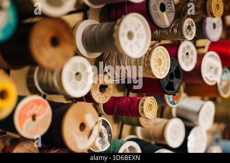 Brightly colored spools of thread neatly organized for sewing projects in a craft room Stock Photo