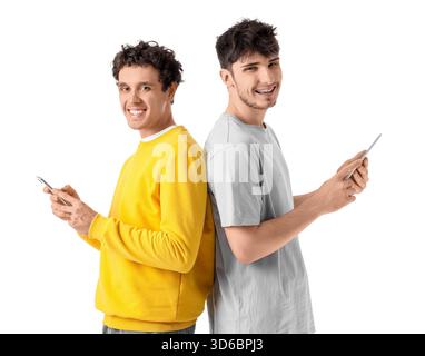 Young brothers using mobile phone and tablet computer on white background Stock Photo