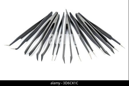 A collection of various black precision tweezers with metal tips is arranged in a semi-circle on a white background. Each tweezer has a different tip Stock Photo