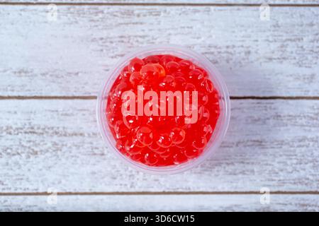 A top down view of a condiment cup filled with popping boba. Stock Photo