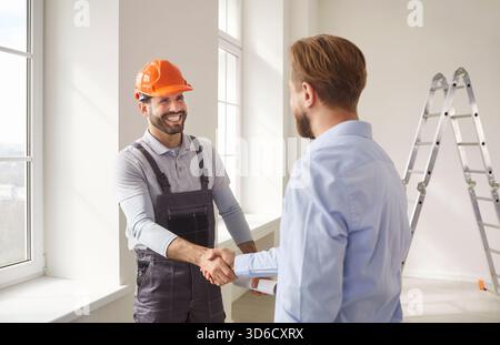 Man client shaking hands with architect or engineer, reaching agreement about construction Stock Photo