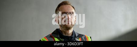 Caucasian Middle Aged Man Wearing Safety Vest and Glasses Working Indoors Stock Photo