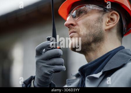 Caucasian Middle Aged Man Using Walkie Talkie While Working Outdoors Stock Photo