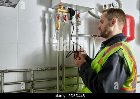 Caucasian Middle Aged Man Inspecting Heating System in Industrial Facility Stock Photo