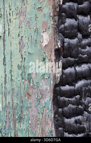 Peeling green paint and burnt black wooden post Stock Photo