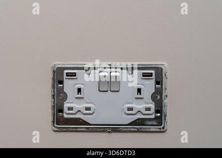 british-style white double electric socket with int usb charging ports, with the cover off Stock Photo