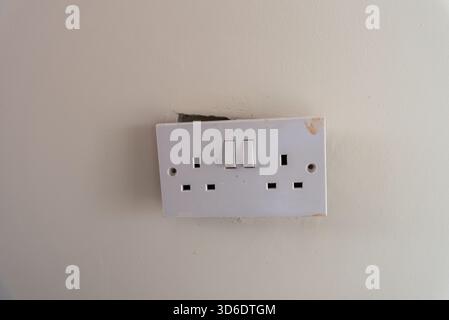 a broken british style double switch electrical socket Stock Photo