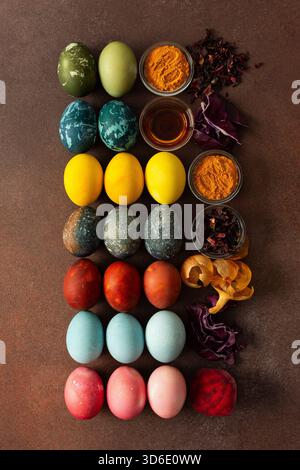 A vibrant assortment of Easter eggs rests on a surface, beautifully dyed in various colors. Natural dye ingredients, such as beets, turmeric and hibis Stock Photo