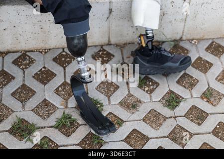 Young man replacing transtibial prostheses for daily walking and sporting activities, taking off a running blade and putting on an artificial leg with Stock Photo
