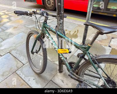 London, England, UK - 25 October 2025: Close up view of a bicycle secured to a lamp post in Regent Street in London with a heavy duty cycle lock Stock Photo