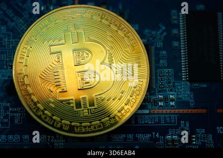 Golden Bitcoin coin on a computer motherboard symbolizing cryptocurrency and digital finance Stock Photo
