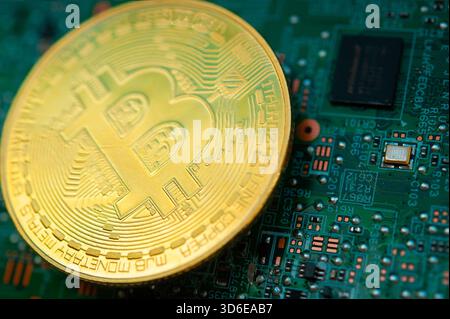 Golden Bitcoin coin on a computer motherboard symbolizing cryptocurrency and digital finance Stock Photo