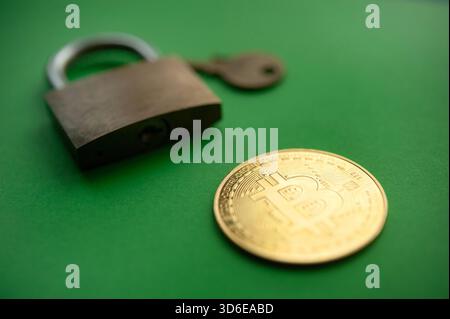 Golden Bitcoin coin next to padlock and key symbolizing security in cryptocurrency and digital assets Stock Photo