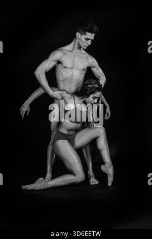 Black and white portrait of male and female ballet dancers striking elegant poses against a studio backdrop Stock Photo