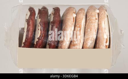 Chocolate and milk coated crackers in a paper box covered with a clear plastic bag isolated nature background with clipping path Stock Photo