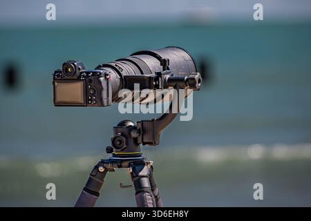 Camera mounted on a tripod ready for professional photography or video shooting. Stock Photo