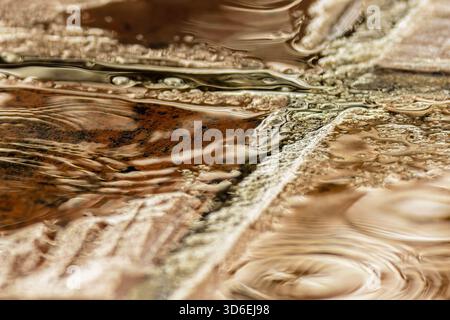 Rain falling on a clay tile floor forming puddles on it, close-up view captured in a farmhouse in the eastern Andean mountains of central Colombia Stock Photo