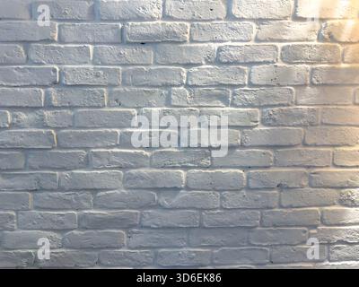 White brick wall under soft afternoon lighting, textured surface and subtle shadows Stock Photo