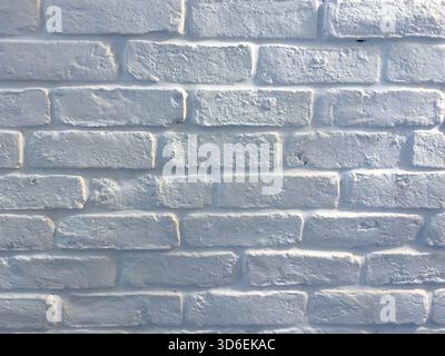 Textured white brick wall under soft daylight, showing rough surface details and subtle shadows Stock Photo