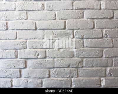 Textured white brick wall under soft daylight, showing rough plaster details and subtle shadows Stock Photo