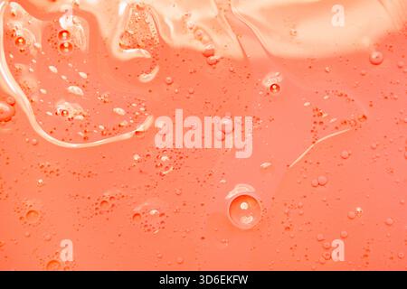 A vibrant orange liquid background showcasing delicate bubbles and swirling patterns, creating a dynamic and abstract visual effect. Ideal for creativ Stock Photo