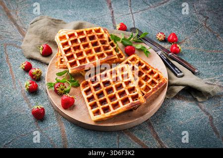 fresh baked homemade Brussels waffles with fresh strawberries on a plate Stock Photo