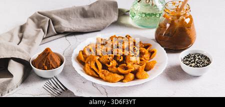 Spicy miso pasta shells on a plate on the table web banner Stock Photo