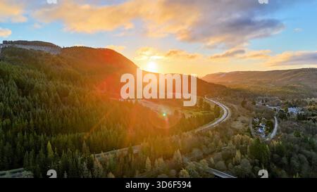 Drone photograph showing the A9 road, and surrounded by a bright and snowy winter landscape near Pitlochry in the Scottish Highlands Stock Photo