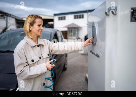 Woman inflating car tire at self-service station Stock Photo