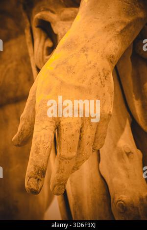 A close-up of a marble hand from a classical sculpture, showing detailed texture, craftsmanship, and the elegant form of ancient stone artistry. Stock Photo