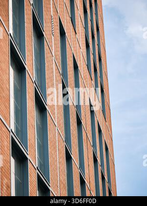Modern brick facade with repeating geometric window pattern used in architecture and business design Stock Photo