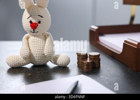 Alimony. Coins, toy bunny, documents and pen on dark table, closeup Stock Photo