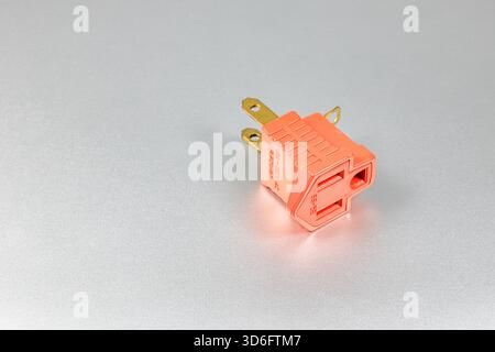 Orange plugs adapters for NEMA plug type B convert to type A with grounded contact isolated on white background. Stock Photo