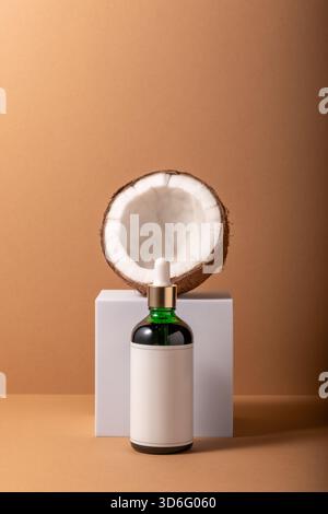 Cracked coconut on white stand with small bottle. Minimal mock up concept. Stock Photo